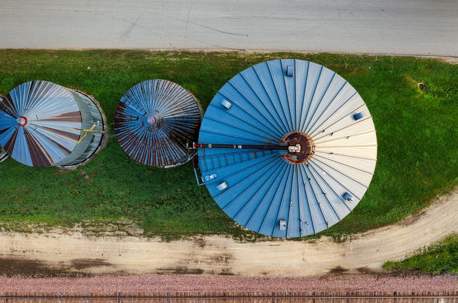 Drone shot capturing top view of three large silos on a Minnesota farm.